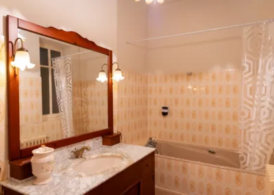 Salle de bain partagée avec baignoire et carrelage rétro dans une maison d’hôtes à Moissac