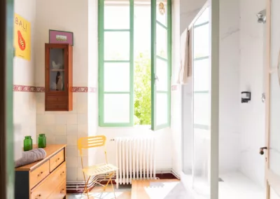 Salle de bain partagée lumineuse avec douche et grande fenêtre dans maison d’hôtes à Moissac