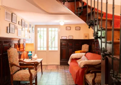 Petit salon d’accueil chaleureux avec fauteuils et canapé dans la maison d’hôtes